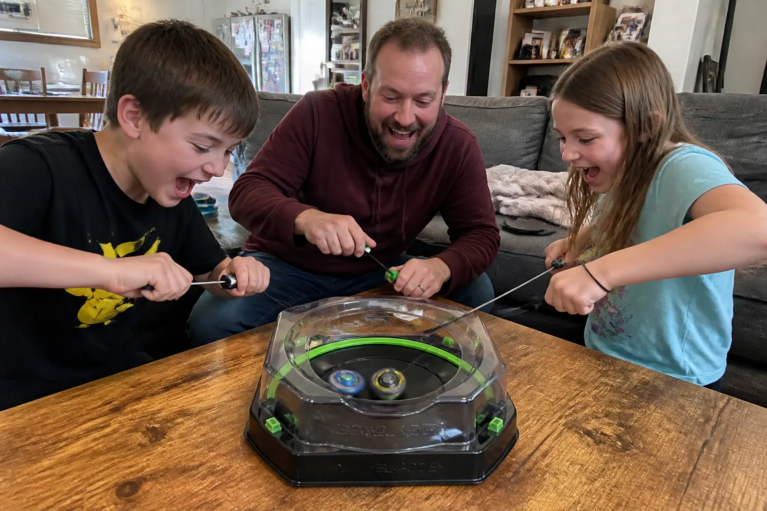 A mixed-age family gathered around a table dueling with the Bamboo Battle Game, phones face-down, everyone laughing