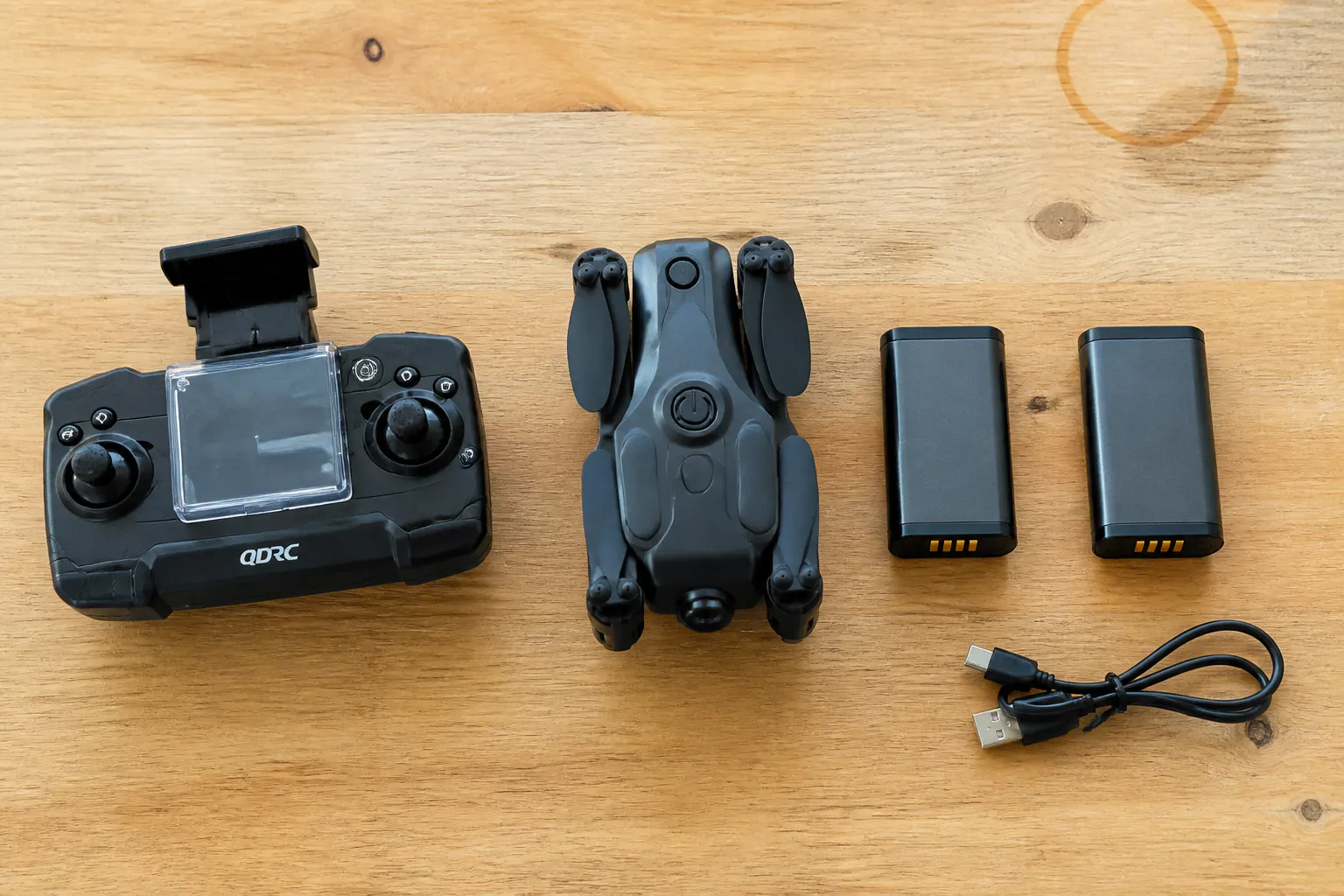Everything included: drone, phone-clamp controller, spare batteries, cables