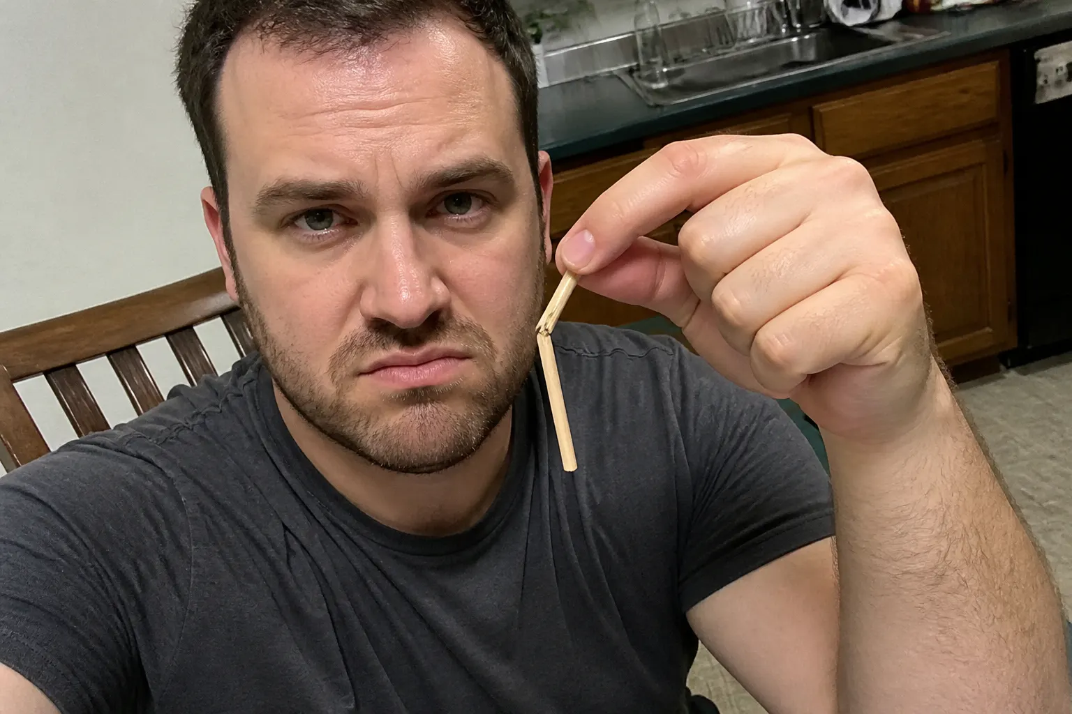 A flimsy bamboo dueling toy with a snapped arm and detached weapon on a table
