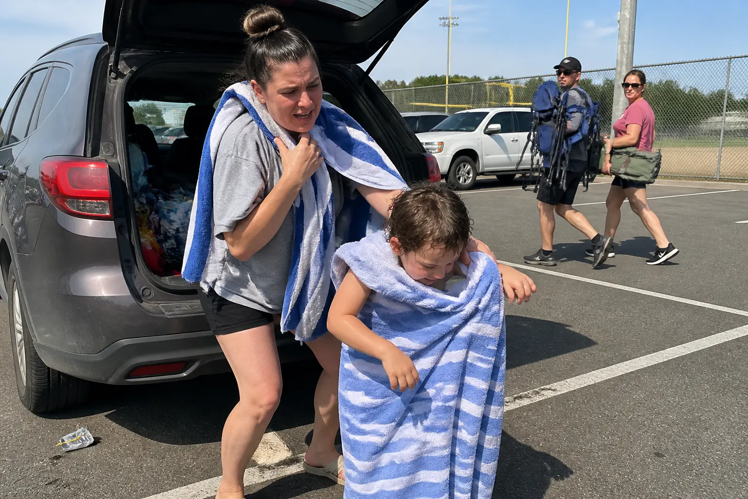 Parent doing the parking-lot towel-dance at the back of an SUV